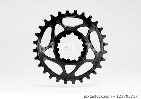 Black round bicycle chainring against white isolated background, floating above the surface. Professional bicycle part. 123703717