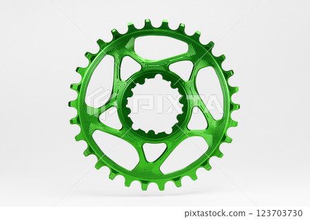 Green round bicycle chainring against white isolated background, floating above the surface. Professional bicycle part. 123703730