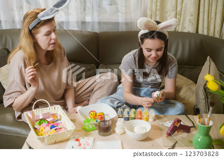 Mother And Daughter Painting Easter Eggs Together. 123703828