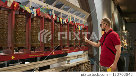 Mumbai, India - February 13, 2024: Man Spins Prayer Wheels - Inside Drum There Are Scrolls On Which Mantra Is Written Several Thousand Times. It Is Believed That Each Time Person Spins Drum Clockwise 123703843