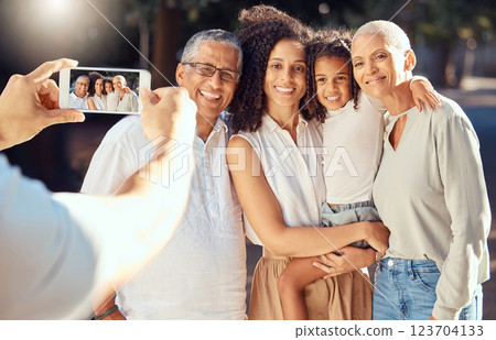 Phone, screen and happy family relax and smile while posing for a picture outdoors together, loving and embracing. Child, mother and grandparents bonding on a trip in nature, hug and enjoy summer Phone, screen and happy family relax and smile while posing for a picture outdoors together, loving and embracing. Child, mother and grandparents bonding on a trip in nature, hug and enjoy summer 123704133
