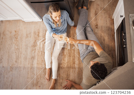 Champagne, cheers and happy couple on the kitchen floor celebrating their new home renovations. Top view of happiness, sparkling wine and toast to the family house of man and woman relaxing together. 123704236