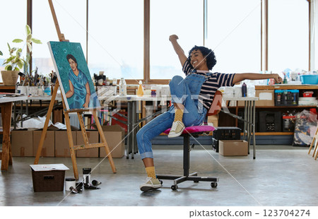 Art, happy and excited woman with painting in studio or design school smiling at finished creative project. Student from India, painter girl and celebration of completed canvas in classroom on chair. 123704274