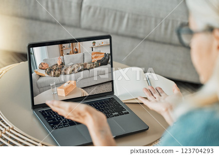 Online consultation, laptop and military woman for therapy with virtual psychologist or therapist talking mental health, trauma or anxiety. Psychology worker with soldier or veteran on a video call 123704293