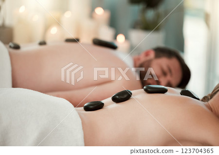 Hot stone, relax and couple with massage at spa for wellness, relax and skin therapy on holiday at a hotel. Man and woman sleeping during luxury natural cosmetics for skin and body health on vacation 123704365