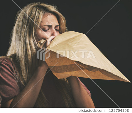 Anxiety, breathing and scared woman with paper bag, mental health and emergency oxygen air for lungs on black background. Panic attack breathe problem, stress and fear of depression, nausea and sick 123704398