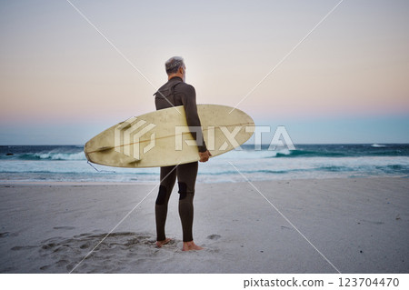 Surfer, surfboard and senior man on beach at sea waves in during sunset during summer vacation in Hawaii. Professional male athlete rest after training or practice surfing sport outdoor at the ocean 123704470