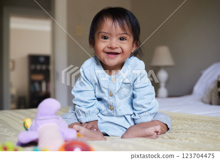 Happy baby with down syndrome, portrait on bed with smile of Mexican kid with special needs relaxed in home. Happy toddler girl in Mexico with disability and cheerful joy sitting in bedroom Happy baby with down syndrome, portrait on bed with smile of Mexican kid with special needs relaxed in home. Happy toddler girl in Mexico with disability and cheerful joy sitting in bedroom 123704475