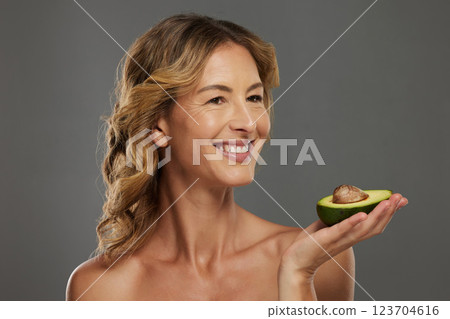 Woman, happy and avocado in hand for health, wellness and detox care with face. Mature model, dermatology and smile with fruit diet for skincare, hair and beauty with natural facial cosmetic product 123704616