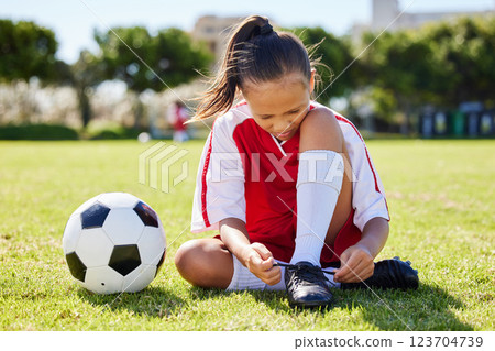 Sports, soccer and tie shoes with girl on grass for fitness, games and training in brazil event. Motivation, workout and exercise with young child on football field for youth, health and wellness 123704739