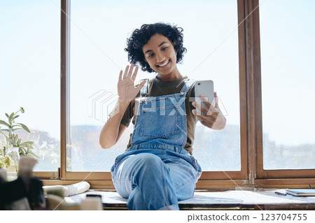 Phone, selfie or video call with a woman on social media while sitting on a table by a window inside with a wave. Communication, networking and internet with a young female using wifi technology 123704755