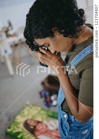 Woman artist with camera, create for digital art to post and sell online or share on social media. Photo of unique painting, canvas with oil NFT and photographer working in creative studio workshop 123704807