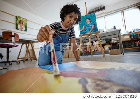 Art, creative and painter painting with watercolor and brush on a canvas at a table in a work studio. Indian design artist, woman or creativity student working as a designer with paint in a workshop Art, creative and painter painting with watercolor and brush on a canvas at a table in a work studio. Indian design artist, woman or creativity student working as a designer with paint in a workshop 123704820