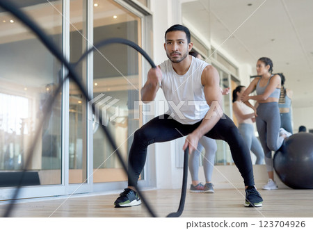 Fitness, battle ropes and man in gym, serious and training with equipment for wellness and exercise. Health club, confident and bilateral wave for cardiovascular benefits, person and bodybuilding Fitness, battle ropes and man in gym, serious and training with equipment for wellness and exercise. Health club, confident and bilateral wave for cardiovascular benefits, person and bodybuilding 123704926