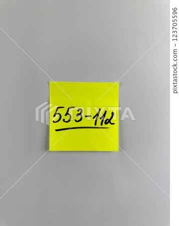 Vertical photo of phone number written on sticky note Vertical photo of phone number written on sticky note 123705596