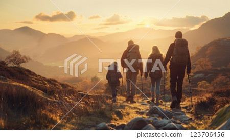 A family takes a break on a mountain hike, feeling energized by the vast, open view, their backpacks and sticks at rest. A family takes a break on a mountain hike, feeling energized by the vast, open view, their backpacks and sticks at rest. 123706456