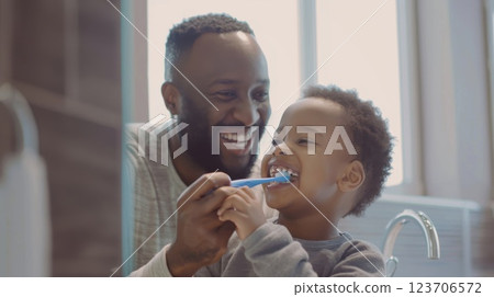 A playful moment of father and son brushing teeth together, teaching the value of hygiene with love and care. childhood, fatherhood A playful moment of father and son brushing teeth together, teaching the value of hygiene with love and care. childhood, fatherhood 123706572