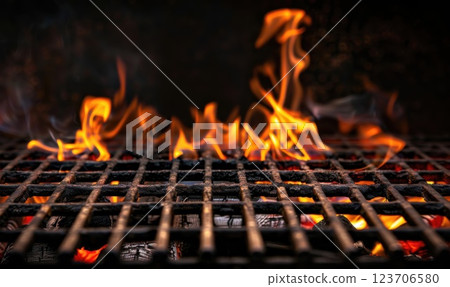 Flames flicker brightly on an empty grill, casting a warm glow on the black background, ready for the next cookout. 123706580