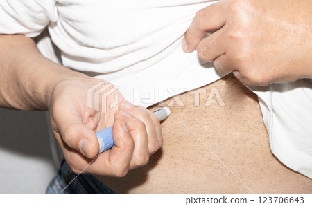 Male patient injecting insulin. Insulin injection pen or insulin cartridge pen for diabetics. 123706643