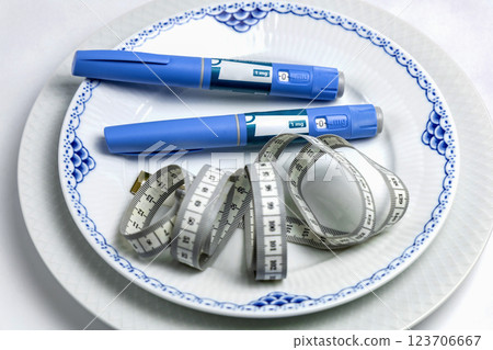 Ozempic Insulin injection pen or insulin cartridge pen for diabetics on a white plate. 123706667