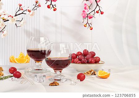 Modern still life with glass of gin or tequila, orange slices, ice and grapes on elegant background with sakura flowers, minimalist bar and summer party concept, advertising banner and menu for cafe. 123706855