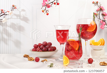 Glasses of grape cocktail, red wine and juice with grape berries, ice and citrus slices on elegant background with spring sakura flowers, bar and summer party concept, restaurant and cafe advertising 123706857