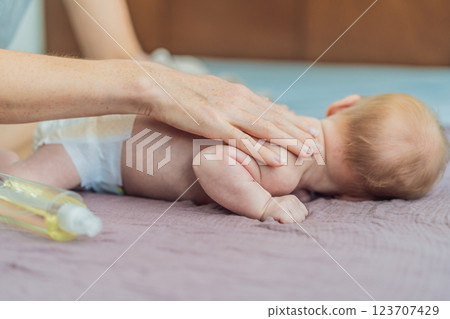 A mother gently massages her 1-month-old baby with baby oil after a bath. This tender moment highlights the bond between parent and child, promoting relaxation, baby care, and the importance of skin A mother gently massages her 1-month-old baby with baby oil after a bath. This tender moment highlights the bond between parent and child, promoting relaxation, baby care, and the importance of skin 123707429