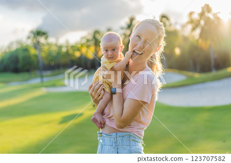 Young mother enjoying a peaceful walk in the park with her one-month-old baby. Motherhood, bonding, and outdoor family time concept 123707582