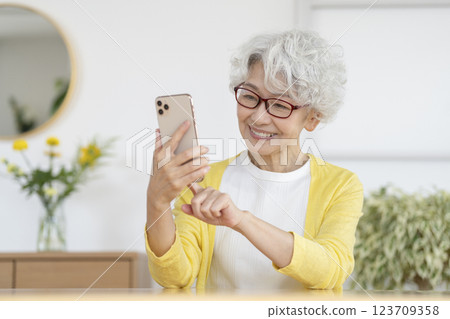 A smiling senior woman operating a smartphone A smiling senior woman operating a smartphone 123709358