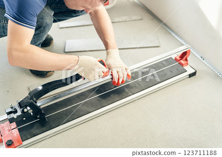 The master prepares the machine for working with floor tiles. With space to copy. High quality photo 123711188