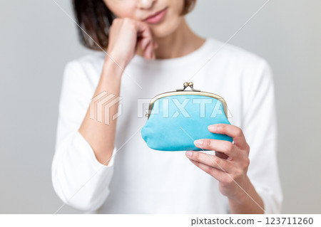 A middle-aged woman worried about her blue wallet A middle-aged woman worried about her blue wallet 123711260