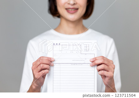 A middle-aged woman smiling with a resume 123711504