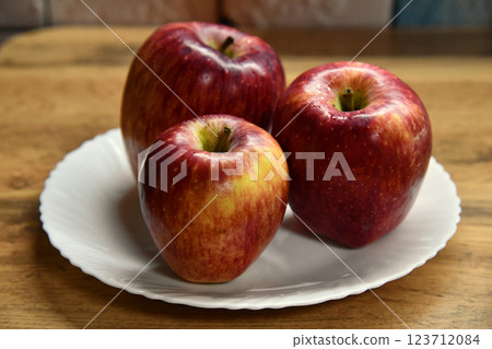 Plate with apples and autumn leaves on wooden table 123712084