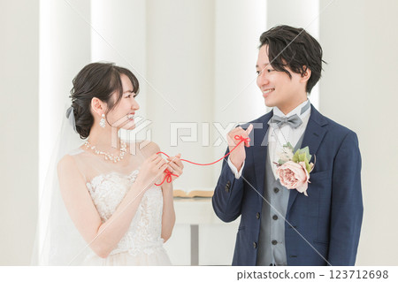 新娘和新郎在婚禮大廳用紅線綁在一起(新娘婚禮) 新娘和新郎在婚禮大廳用紅線綁在一起(新娘婚禮) 123712698