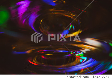Abstract multicolour background. New Year lights. Blurred colourful light on champagne glass. Rainbow flash in dark. Futuristic shiny background. Illuminated effect. Bright glowing. 123712757