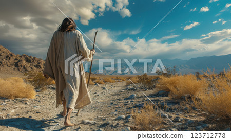 Man in white robe walking on a dirt road with a staff, mountains in the background, Jesus, faith, christianity, hope, pilgrimage 123712778