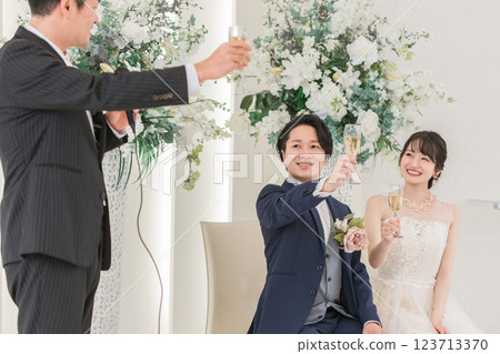 一個男人和新郎新娘在婚禮上敬酒 123713370