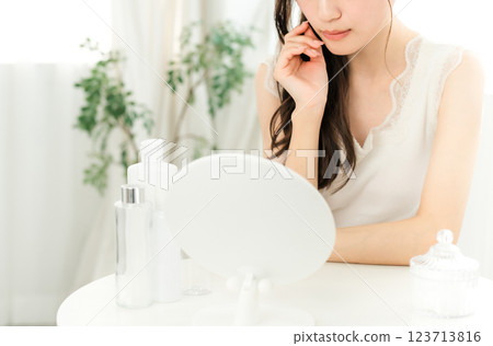 Young Asian woman worried about skin problems while looking in the mirror (skin care) Young Asian woman worried about skin problems while looking in the mirror (skin care) 123713816