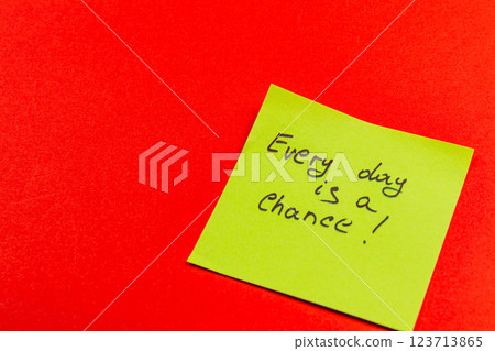 Motivational sticky note on vibrant red background for daily inspiration 123713865