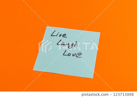 Inspirational message written on sticky note placed on vibrant orange surface 123713898