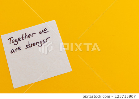 Message of unity on a bright yellow background with handwritten text 123713907