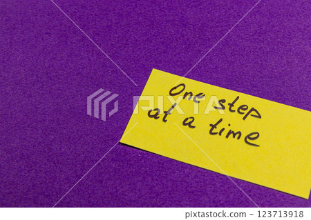Motivational reminder on yellow sticky note placed on purple background 123713918