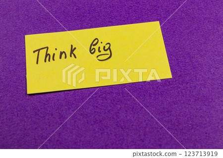Motivational message on a bright yellow note against purple background 123713919