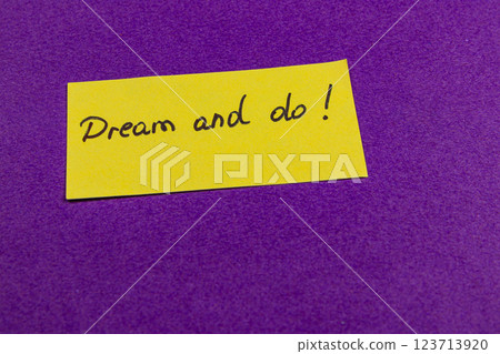Motivational note on bright yellow paper against a purple background 123713920