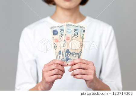 中年婦女拿著一張千日元鈔票 123714303