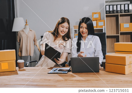 Startup SME small business entrepreneur of freelance Asian woman using a laptop with box Cheerful success Asian woman her hand lifts up online marketing packaging box and delivery SME idea concept 123715031