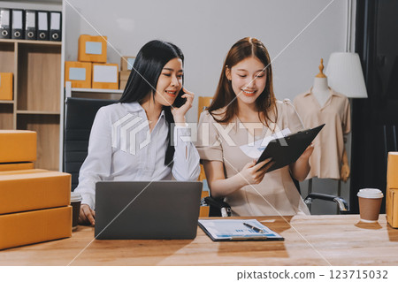 Startup SME small business entrepreneur of freelance Asian woman using a laptop with box Cheerful success Asian woman her hand lifts up online marketing packaging box and delivery SME idea concept Startup SME small business entrepreneur of freelance Asian woman using a laptop with box Cheerful success Asian woman her hand lifts up online marketing packaging box and delivery SME idea concept 123715032