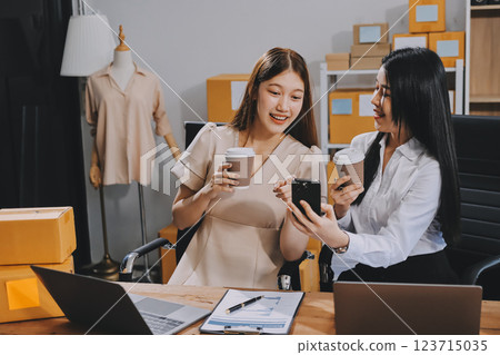 Startup SME small business entrepreneur of freelance Asian woman using a laptop with box Cheerful success Asian woman her hand lifts up online marketing packaging box and delivery SME idea concept Startup SME small business entrepreneur of freelance Asian woman using a laptop with box Cheerful success Asian woman her hand lifts up online marketing packaging box and delivery SME idea concept 123715035