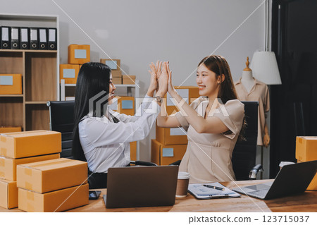 Startup SME small business entrepreneur of freelance Asian woman using a laptop with box Cheerful success Asian woman her hand lifts up online marketing packaging box and delivery SME idea concept Startup SME small business entrepreneur of freelance Asian woman using a laptop with box Cheerful success Asian woman her hand lifts up online marketing packaging box and delivery SME idea concept 123715037