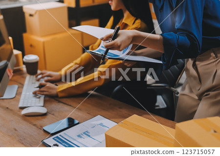 Asian SME business women use laptop computer checking customer order online shipping boxes at home. Starting Small business entrepreneur SME freelance. Online business, Work at home concept. 123715057